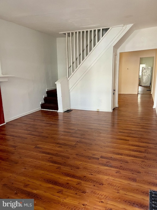 unfurnished living room with dark wood-type flooring