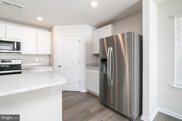 kitchen featuring stainless steel appliances, wood-type flooring, and white cabinetry