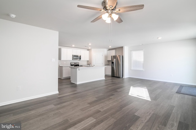 unfurnished living room featuring ceiling fan, dark hardwood / wood-style flooring, and sink