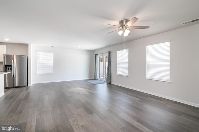 unfurnished living room with dark hardwood / wood-style flooring and ceiling fan