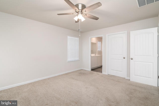 unfurnished bedroom with carpet flooring, connected bathroom, and ceiling fan