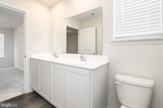 bathroom with toilet, vanity, and hardwood / wood-style flooring