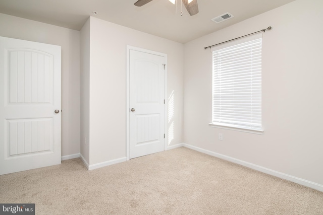 unfurnished bedroom featuring multiple windows, a closet, ceiling fan, and light colored carpet