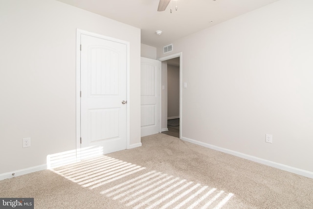 unfurnished bedroom featuring a closet, light carpet, and ceiling fan