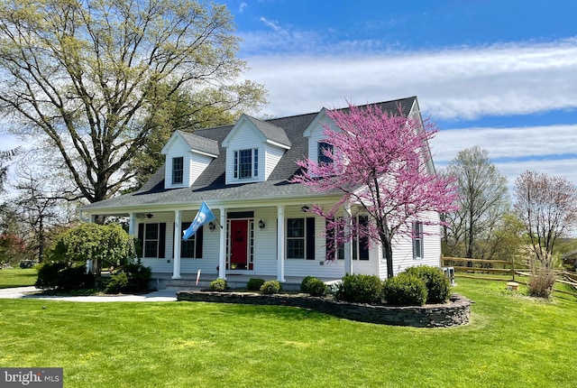 cape cod home featuring a porch and a front lawn