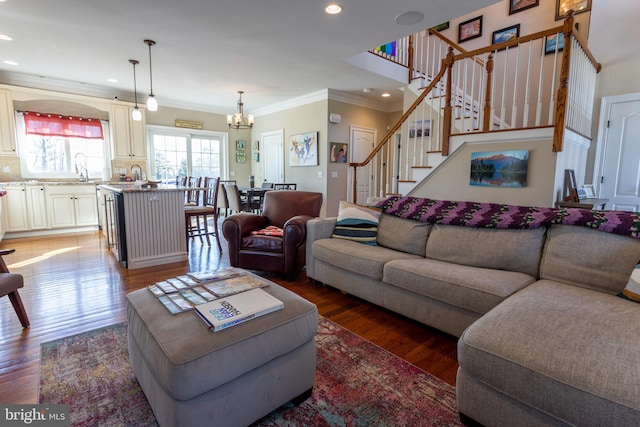 living room with sink, a chandelier, crown molding, and dark hardwood / wood-style floors