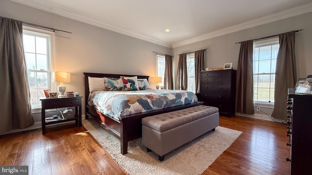 bedroom with wood-type flooring, multiple windows, and ornamental molding