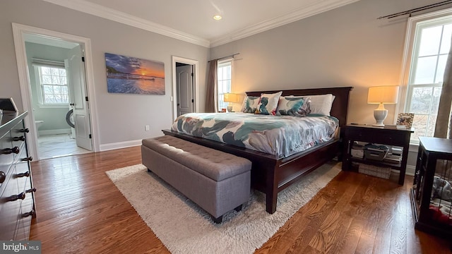 bedroom featuring hardwood / wood-style flooring, multiple windows, and connected bathroom