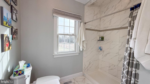 bathroom featuring a healthy amount of sunlight, a shower with shower curtain, and toilet