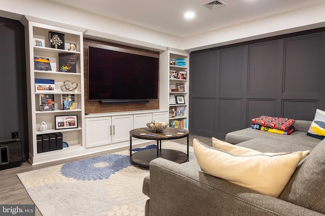 living room with light hardwood / wood-style floors and built in shelves