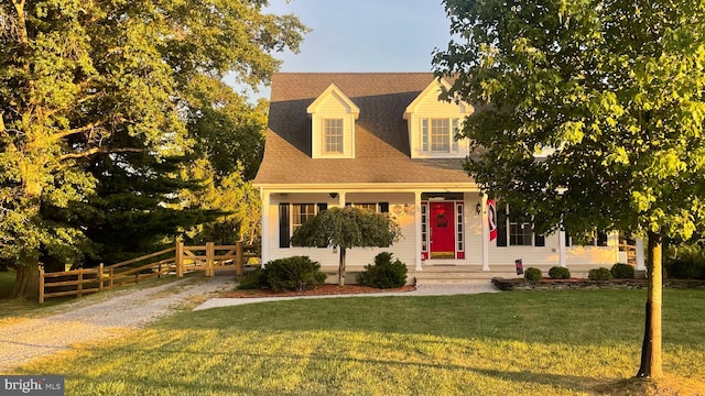 cape cod home featuring a front yard