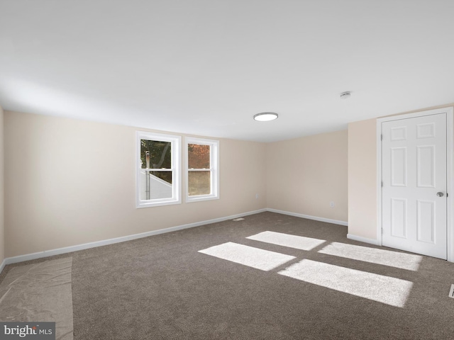 unfurnished room with dark colored carpet