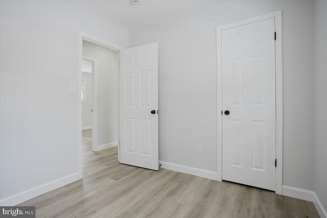 unfurnished bedroom featuring a closet and light hardwood / wood-style floors