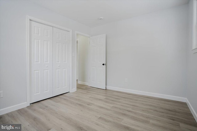 unfurnished bedroom featuring light hardwood / wood-style flooring and a closet