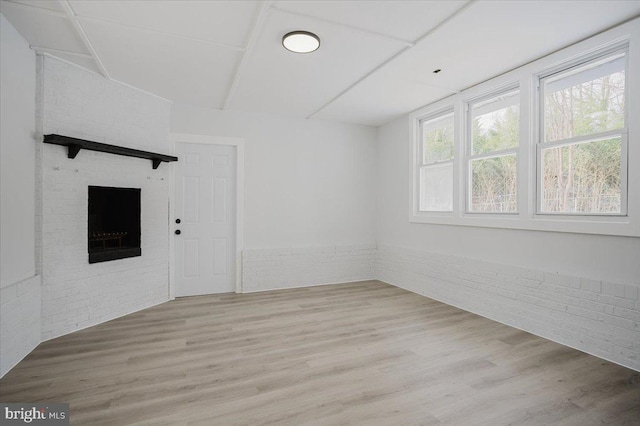 spare room with hardwood / wood-style flooring and brick wall