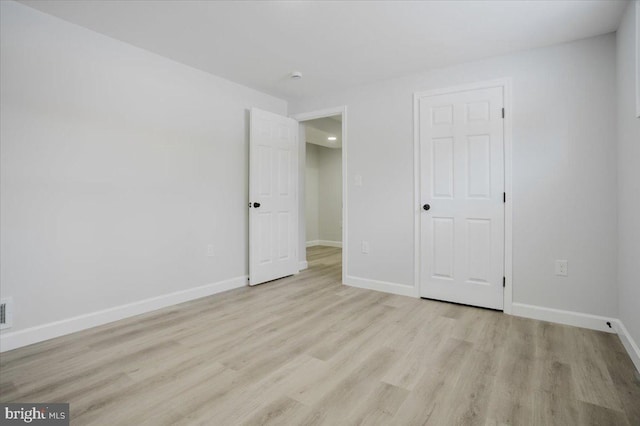 unfurnished bedroom featuring light wood-type flooring and a closet