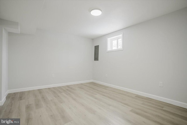 unfurnished room featuring electric panel and light hardwood / wood-style floors