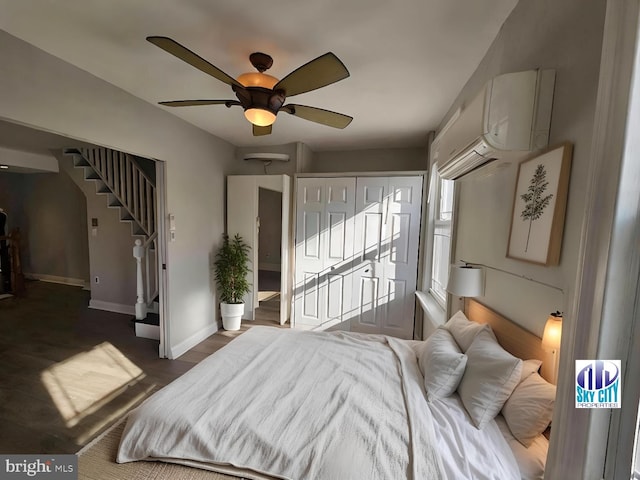 bedroom with ceiling fan, dark wood-type flooring, and a wall unit AC