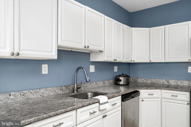 kitchen with sink, dishwasher, dark stone counters, and white cabinets