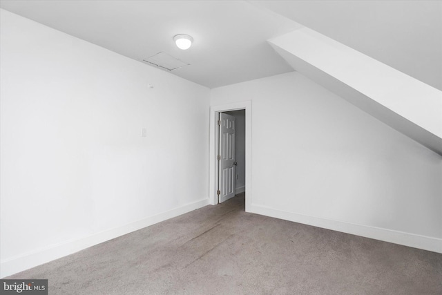 bonus room with light carpet and vaulted ceiling