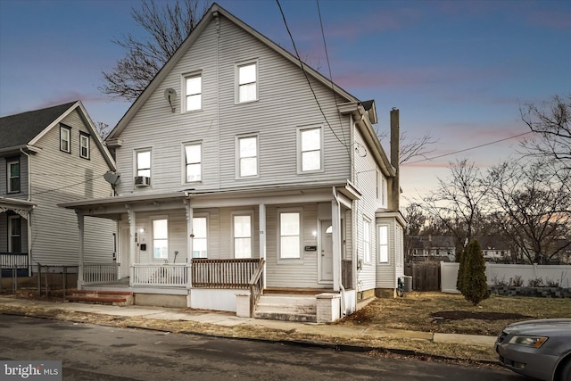 view of front property featuring cooling unit and covered porch