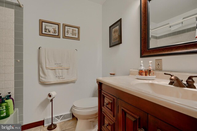 bathroom with toilet, tile patterned flooring, a shower, and vanity