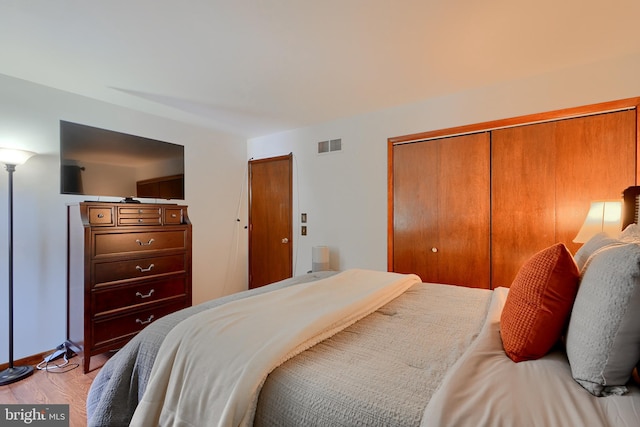 bedroom with light wood-type flooring and a closet