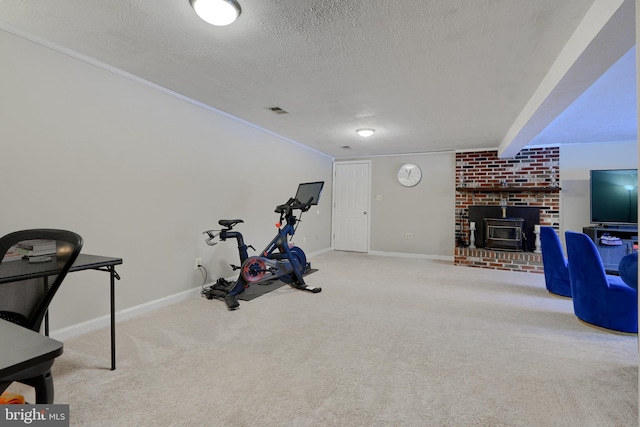 workout room with a wood stove, a textured ceiling, and light carpet