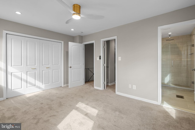 unfurnished bedroom with ceiling fan, light carpet, connected bathroom, and a closet