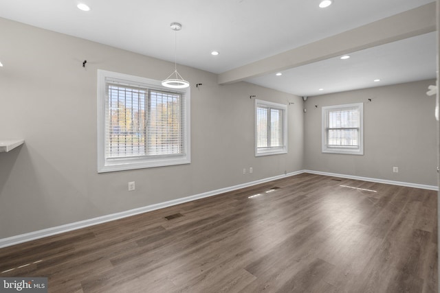 unfurnished dining area featuring dark hardwood / wood-style flooring and beamed ceiling