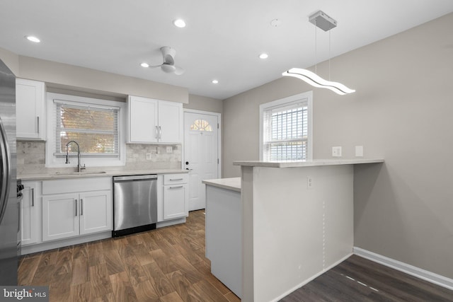 kitchen featuring stainless steel dishwasher, decorative light fixtures, white cabinetry, and sink