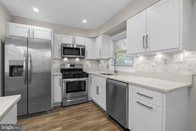 kitchen featuring white cabinetry, sink, stainless steel appliances, and light stone counters