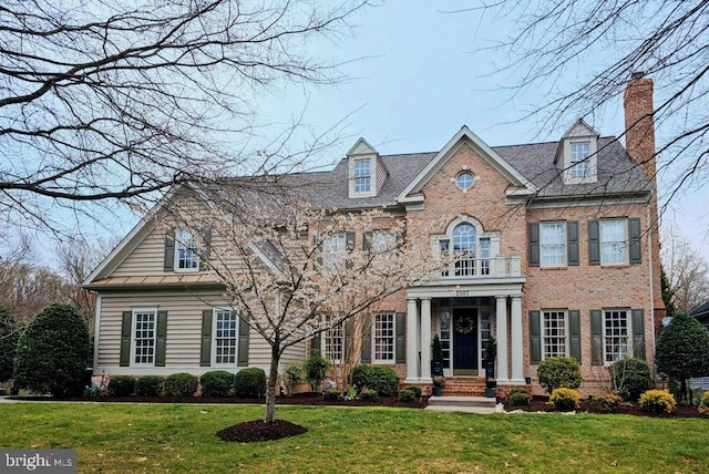 view of front of property featuring a balcony and a front lawn