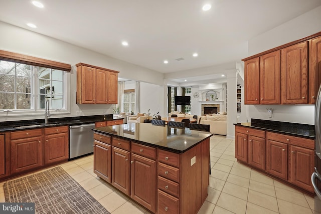 kitchen with dishwasher, sink, dark stone countertops, and light tile patterned floors