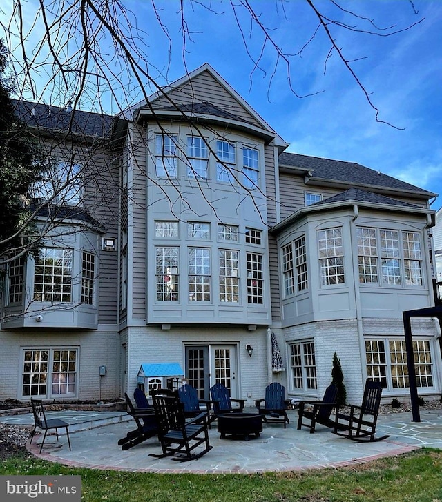 back of house with a fire pit, a patio, and french doors