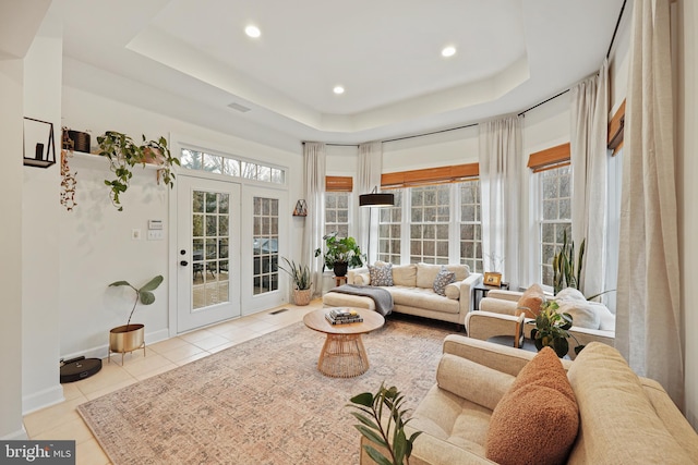 sunroom featuring a tray ceiling and french doors