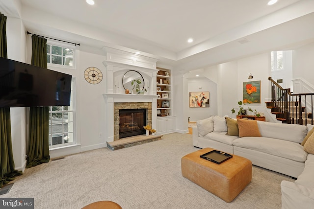 carpeted living room featuring built in features and a fireplace