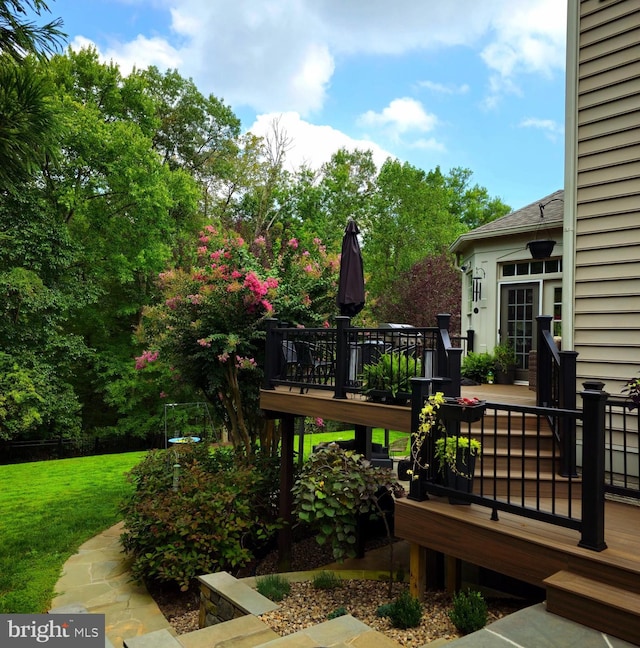 wooden deck featuring a lawn