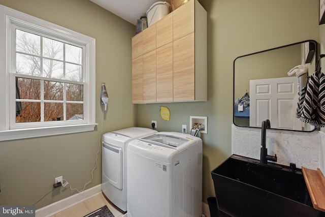 laundry room with cabinets, light tile patterned flooring, sink, and independent washer and dryer