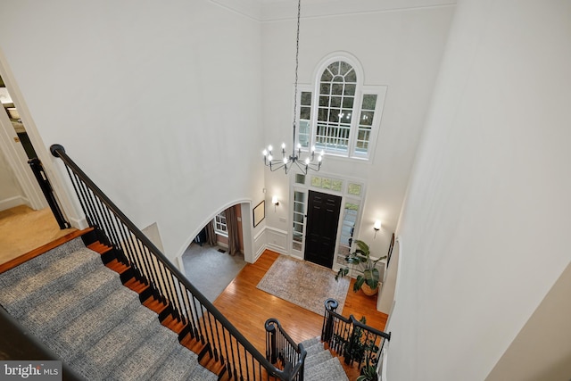 foyer featuring a high ceiling, light wood-type flooring, and an inviting chandelier