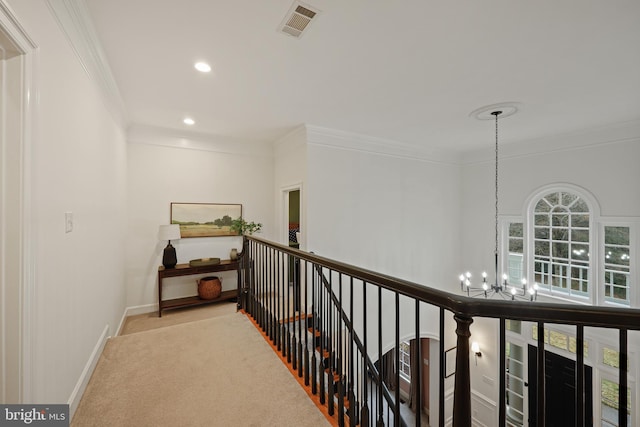 corridor featuring an inviting chandelier, light colored carpet, and ornamental molding