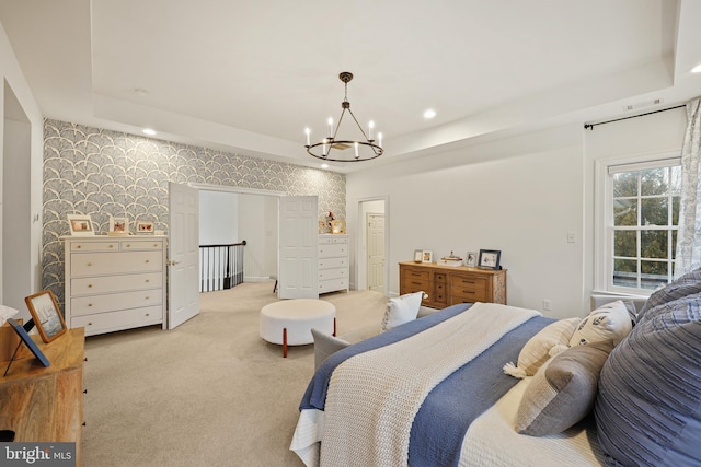 bedroom with a raised ceiling, light colored carpet, and an inviting chandelier