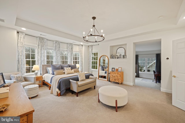 carpeted bedroom featuring an inviting chandelier and a raised ceiling