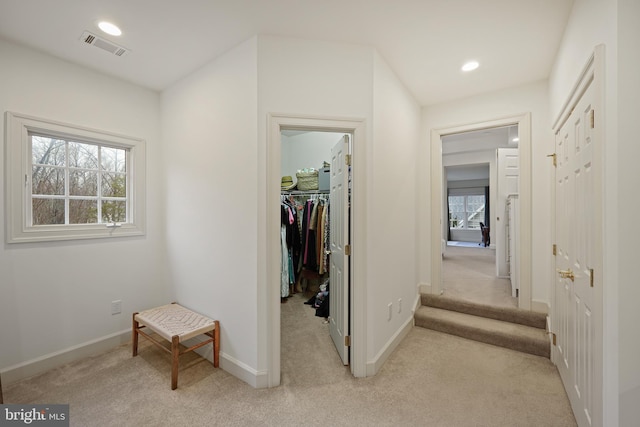 corridor featuring light colored carpet