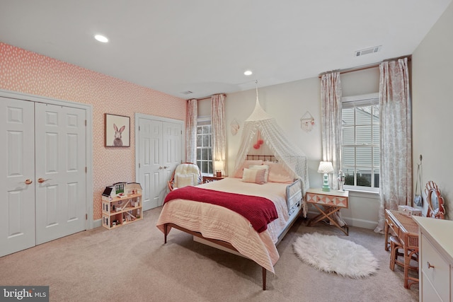 carpeted bedroom with multiple closets