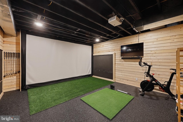 interior space with golf simulator and wooden walls