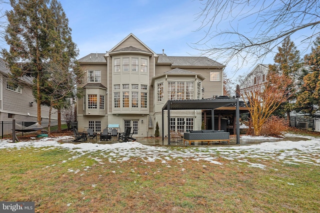 snow covered house featuring a pergola, a jacuzzi, a lawn, and french doors