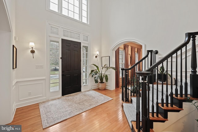 foyer with a towering ceiling and light hardwood / wood-style flooring