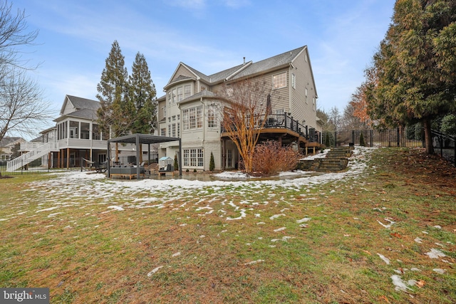 back of house with a yard, a sunroom, and a deck