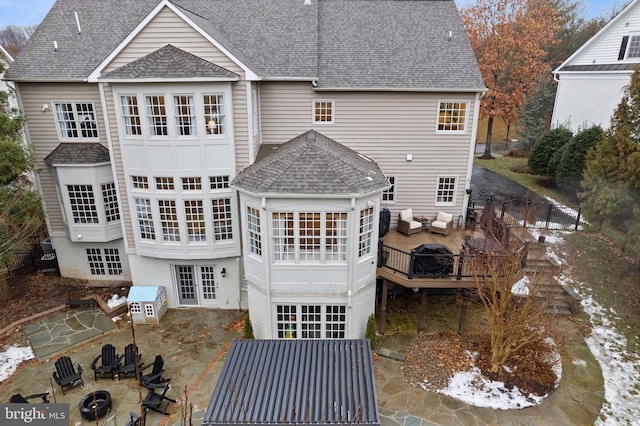 back of house featuring a wooden deck, an outdoor living space with a fire pit, and a patio area